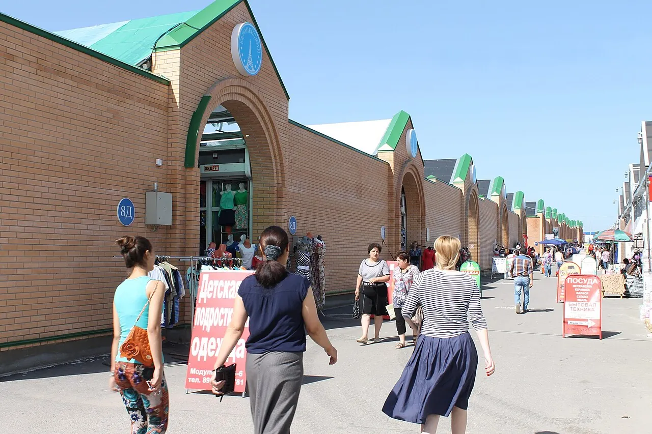 Ряды кирпичных павильонов и покупатели на рынке «Лира» в Пятигорске